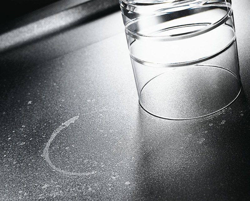 Vodný kameň na čiernom granitovom dreze — biele škvrny po odparení vody