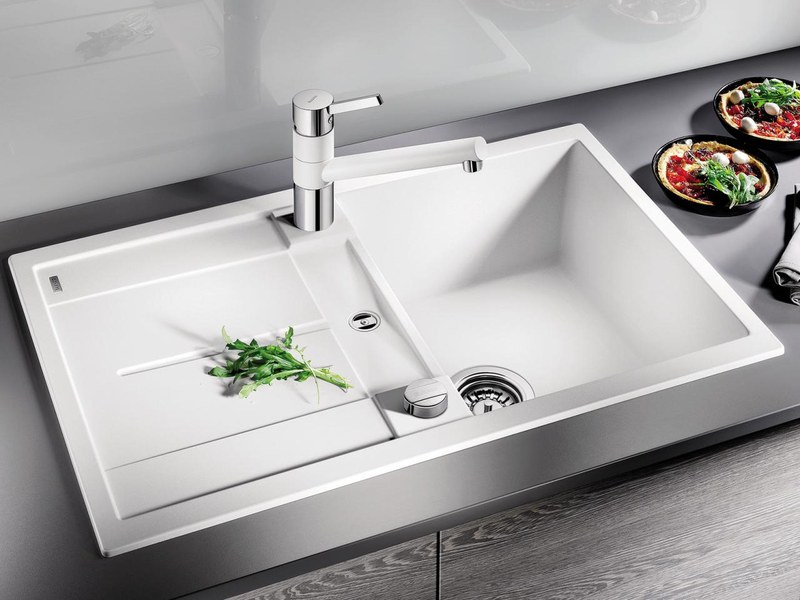 Stojánková kuchynská batéria namontovaná na bielom granitovom dreze