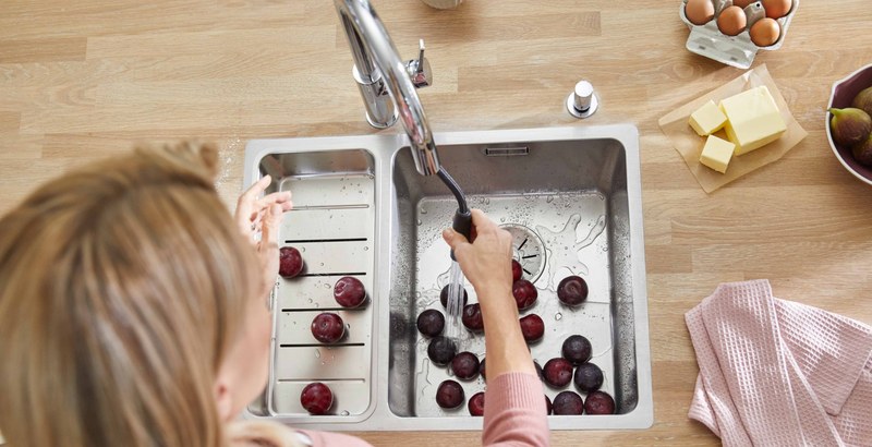 Výsuvná sprška v akcii — oplachovanie ovocia v kuchynskom dreze